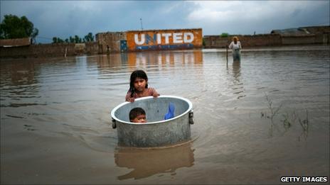 A girl floats her brother across floodwaters in Sukkur (7 August 2010)