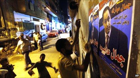 Egyptian activists of the Popular Coalition to Support Gamal Mubarak hang posters promoting the son of President Hosni Mubarak as the country's next leader, in Cairo, Egypt (21 August 2010). The Arabic reads "Gamal for all Egyptians".
