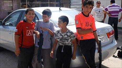 Children at a Baghdad refuge centre holding toy guns