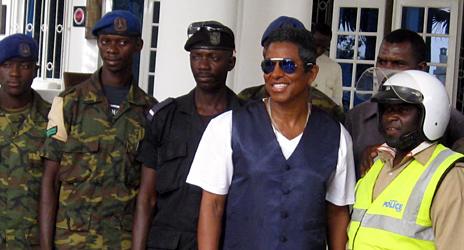 Jermaine Jackson (second right) poses for photos with Gambia soldiers and police officers