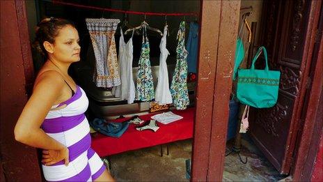 seamstress stands outside shop