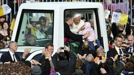 Ten-month-old Ronke Ijanson is handed to the Pope