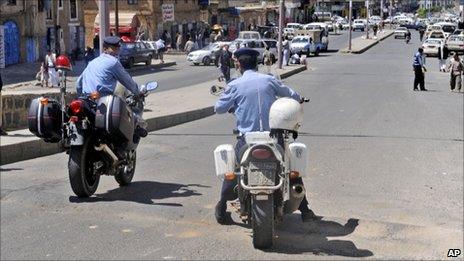 Yemeni policemen attend the scene where an attack took place on a convoy carrying a senior British diplomat in Sanaa