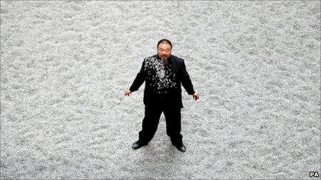 Ai Weiwei standing on seeds