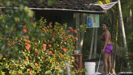 A woman in a village along an Amazon tributary stands near a campaign flag for presidential candidate Dilma Rousseff on 31 October