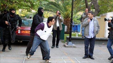 Greek police escort Panayotis Argyrou to a public prosecutor's office in Athens, 2 November