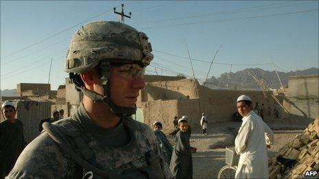 Boys watch US soldier on patrol in Kandahar
