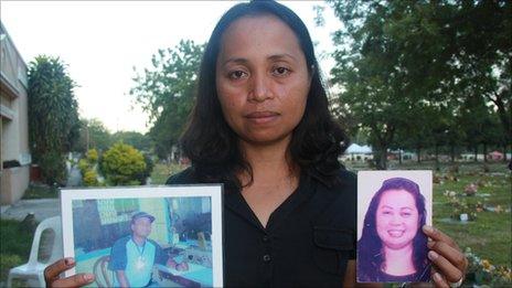 Grace Morales holding pictures of her husband and sister who were killed in the Maguindanao massacre, picture taken November 2010