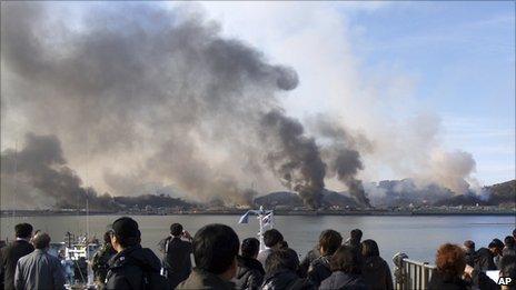 South Koreans watch smoke rising from Yeonpyeong island on 23 November 2010