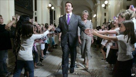 Arnold Schwarzenegger slapping the hands of school children