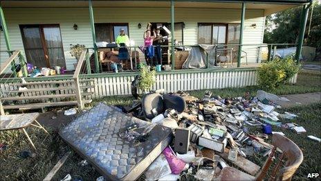 The Williams family throw damaged belongings outside their home at Fernvale, near Ipswich, southwest of Brisbane, Queensland