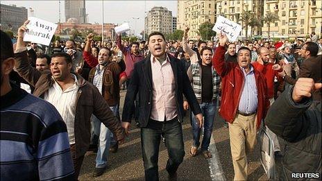 Crowd in Tahrir Square, Cairo carrying signs against President Mubarak.