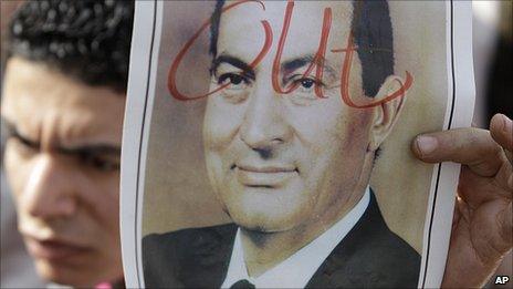 Protester holds photo of Hosni Mubarak with 'out' written across it