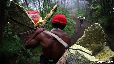 Miner carrying heavily laden baskets