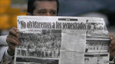 Politician Armando Acuna holds a newspaper with an article headlined, "We will not forget the kidnapped" upon his arrival at Catam airport in Bogota February 11, 2011