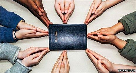 Hands round a bible