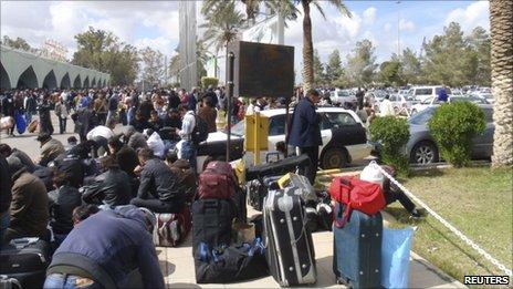 People waiting to be evacuated from Libya gather outside Tripoli airport