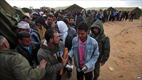 Egyptians who have fled Libya wait for their breakfast in a makeshift refugee camp set up by the Tunisian army, at the Tunisia-Libyan border, in Ras Ajdir, Tunisia, 25 February 2011