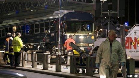 Investigators work around the bus attacked at Frankfurt Airport, 2 March