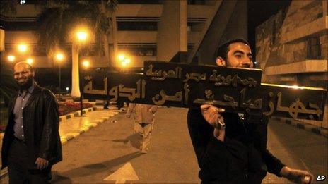 Protester with the sign of the state security building in Nasr City, Cairo, 5 March