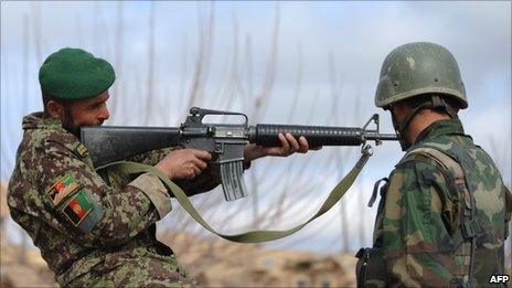 An Afghanistan National Army (ANA) soldier checks a weapon in Helmand Province on 2 March 2011