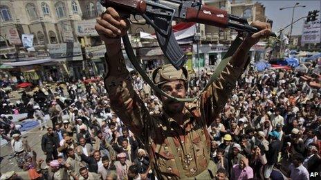 A Yemeni army officer reacts holding up his AK-47 as he and other officers join anti-government protestors in Sanaa, Yemen (21March 2011)