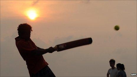 Youngster plays cricket on a beach in Colombo