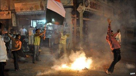 Indian cricket fans celebrates with fireworks as they wave flags in a street of Hyderabad on March 30, 2011