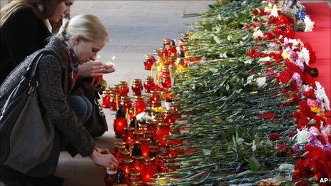 People light candles at a memorial to those killed in the metro station blast (12 April 2011)