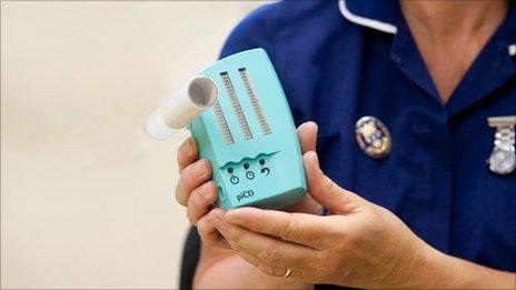 A nurse holding a carbon monoxide tester