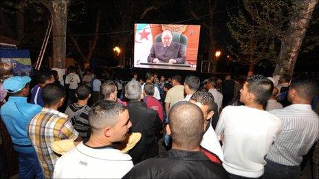 Algerians gather to watch President Bouteflika's speech on a giant screen in Telemcen, 15 April