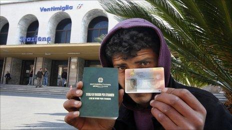 A Tunisian migrant shows his Italian-issued travel documents near the Italian-French border (21 April 2011)