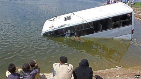 Egyptians look at a sunken minibus in which twenty-two people drowned when it fell into the Nile River in the southern Egyptian town of Beni Suef, 110 km south of Cairo, 29 April 2011.