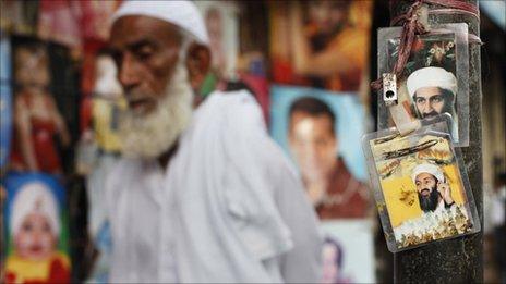 A man walks past images of al-Qaeda leader Osama Bin Laden displayed near a poster shop selling his images in Karachi, Pakistan, on 4 May 2011