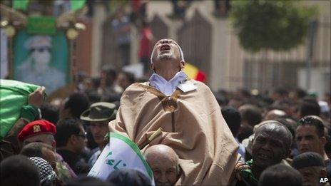 In this photo made on a government organised tour, a supporter reacts during funeral ceremony for members Gaddafi family in Tripoli, Libya, Monday 2 May 2011