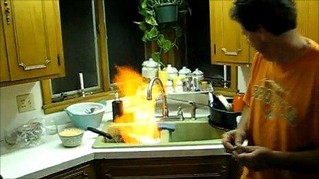 Video footage of man appearing to set alight water from a tap (Image taken from YouTube)