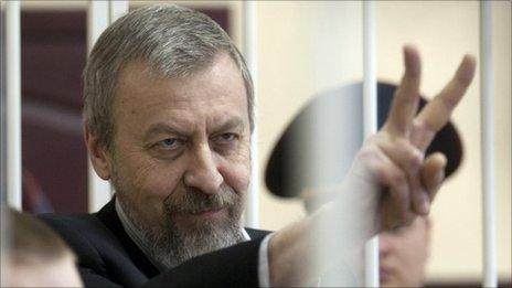 Andrei Sannikov gestures in a guarded cage during a court hearing in Minsk, May 14, 2011