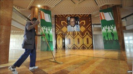 A worker cleans the floor in the lobby inside the Felix Houphouet-Boigny Fondation building in Yamoussoukro on 19 May 2011