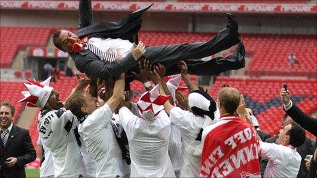 Brendan Rodgers is thrown into the air by his jubilant Swansea players