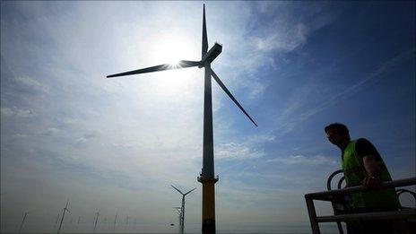 A maintenance worker by a offshore wind turbine