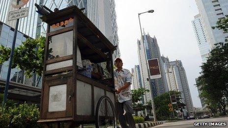 A food vendor pushes his cart at Jakarta