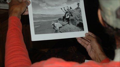 A former freedom fighter looks at a photo of his friends and colleagues