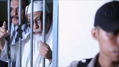 Muslim cleric Abu Bakar Ba'asyir is seen behind bars before his hearing verdict at the South Jakarta District Court on June 16, 2011 in Jakarta, Indonesia