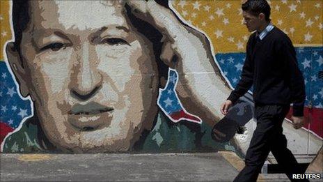 A man walks past graffiti depicting Venezuelan President Hugo Chavez in Caracas 27 June, 2011.