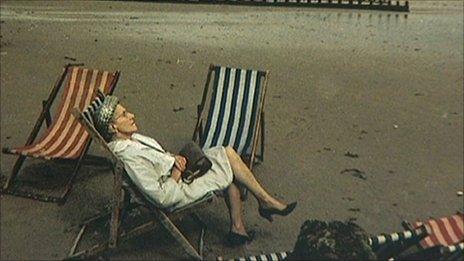 A woman asleep on a stripy deck chair