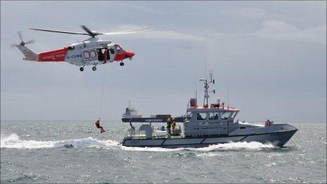 Guernsey firefighter being transferred between the Portland coastguard helicopter and the Sea Fisheries vessel the Leopardess