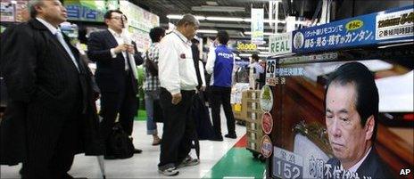 People watch live TV broadcasting in a Tokyo discount store from the Diet as Japanese Prime Minister Naoto Kan reacts after he survived a no-confidence motion during Lower House plenary session Thursday, June 2, 2011