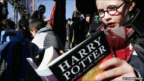 Child holds a copy of Harry Potter