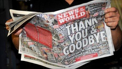 Printer James Bradley reads the final edition of the News of the World newspaper as it rolls off the press