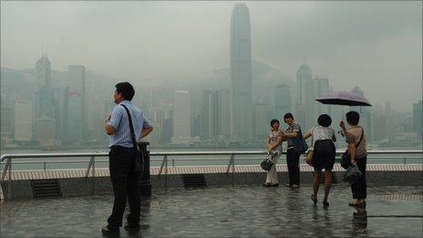 Tourist takes pictures against Hong Kong's harbour on July 12.